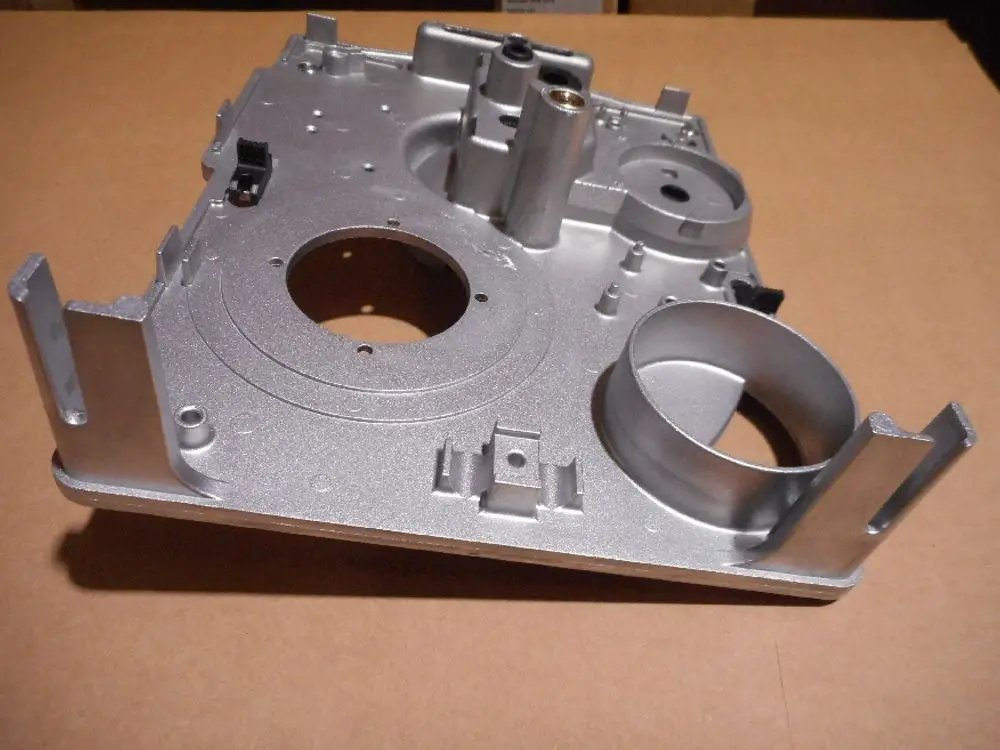 Silberne Metallplatte mit verschiedenen Ausschnitten und Halterungen, vermutlich für eine technische Anwendung, möglicherweise von der Marke Remeha.